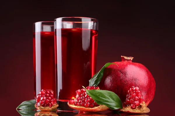 熟した pomergranate と赤の背景にジュースのグラス — ストック写真