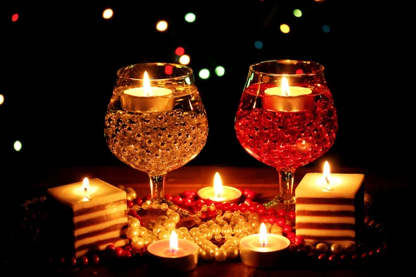 Incroyable composition de bougies et de verres sur table en bois sur fond lumineux — Photo