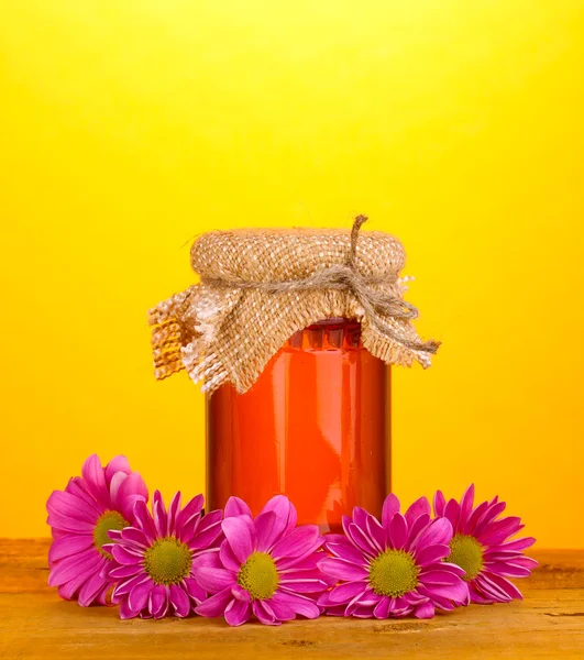 Dolce miele in vaso su tavola di legno su fondo giallo — Foto Stock