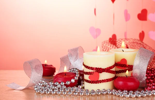 Velas para o Dia dos Namorados na mesa de madeira no fundo vermelho — Fotografia de Stock