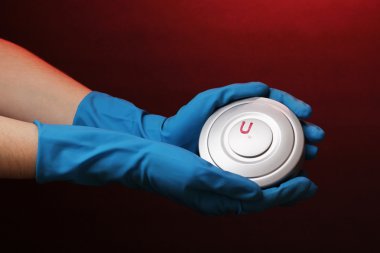 Uranium in hand on red background clipart