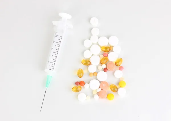 Syringe and tablets isolated on white — Stock Photo, Image