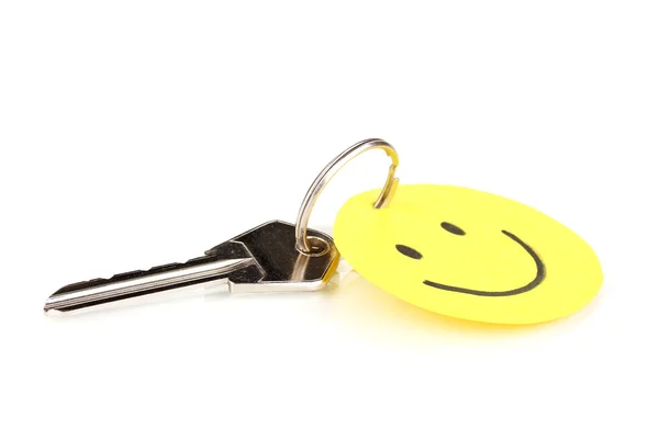 Ключ с шармом улыбки изолирован на белом — стоковое фото