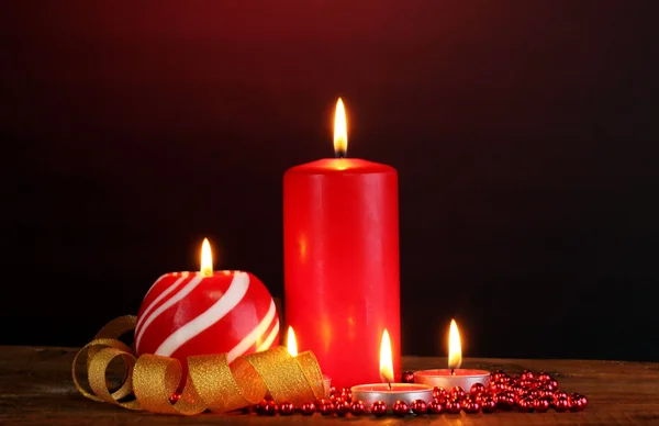 Wspaniałe świece na drewnianym stole na ciemnym tle — Zdjęcie stockowe