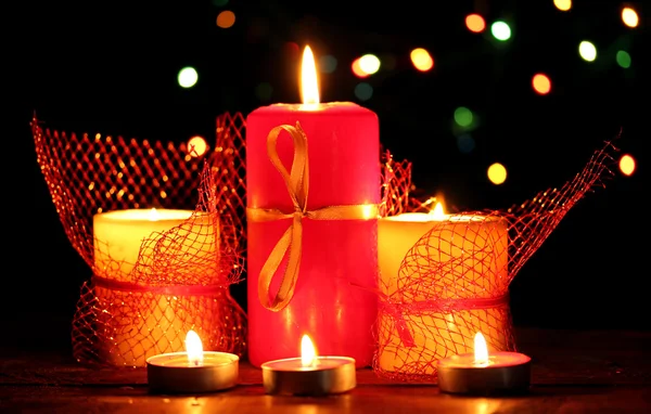 Maravilhosas velas na mesa de madeira no fundo brilhante — Fotografia de Stock