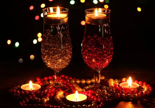 Increíble composición de velas y vasos sobre mesa de madera sobre fondo brillante — Foto de Stock