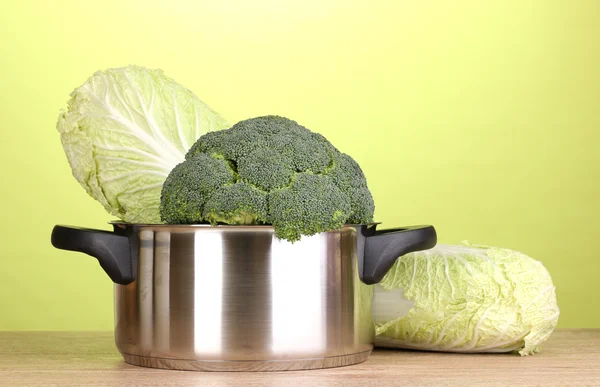 Tencere ile brokoli ve lahana yeşil zemin üzerine ahşap tablo — Stok fotoğraf