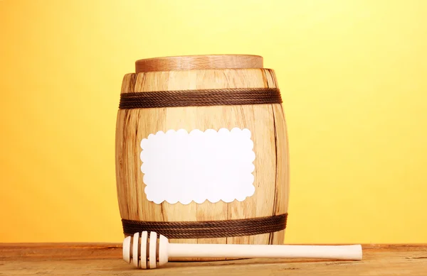 Miel dulce en barril con rociador sobre mesa de madera sobre fondo amarillo —  Fotos de Stock