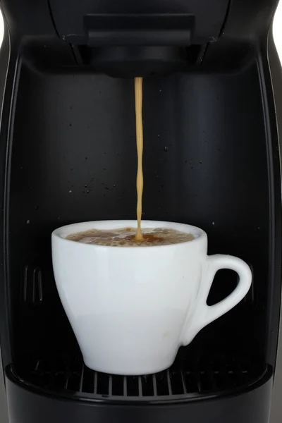 Еспресо-машина заливає каву в білій чашці — стокове фото