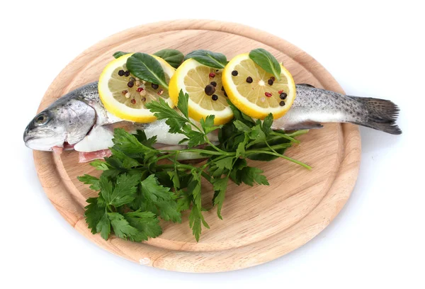 Pesce fresco con limone, prezzemolo e pepe su tagliere di legno isolato su bianco — Foto Stock