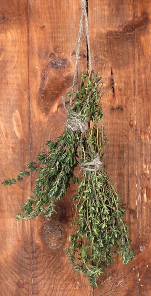 木制背景上的绳子上挂着的新鲜绿色百里香 — 图库照片