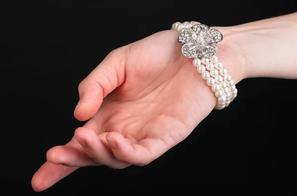 Perlenarmband an der Hand isoliert auf schwarz — Stockfoto