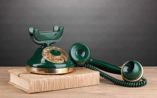 Retro telefonen stående på bok på träbord på grå bakgrund — Stockfoto