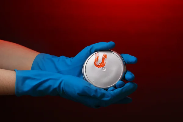 Elinde kırmızı bir arka plan üzerinde uranyum — Stok fotoğraf