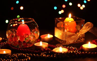 Wonderful composition of candles on wooden table on bright background clipart