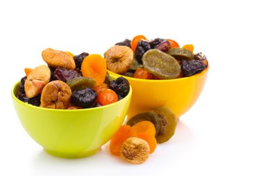 Dried fruits in bright bowls isolated on white