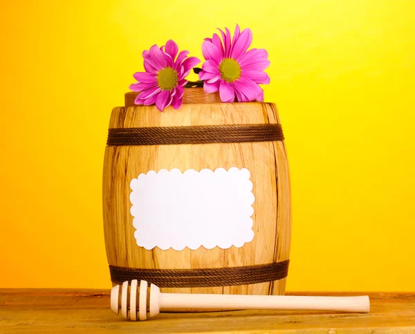 stock image Sweet honey in barrel with drizzler on wooden table on yellow background