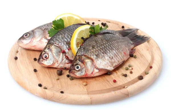 Friss halak, citrommal, petrezselyem és fűszer elszigetelt fehér fa vágódeszka — Stock Fotó