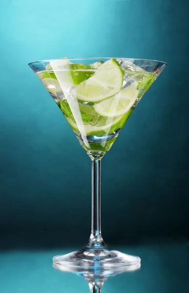 Стакан коктейля с лаймом и мятой на синем фоне — стоковое фото