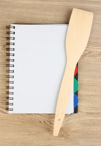 Libro de cocina abierto y utensilios de cocina sobre fondo de madera — Foto de Stock