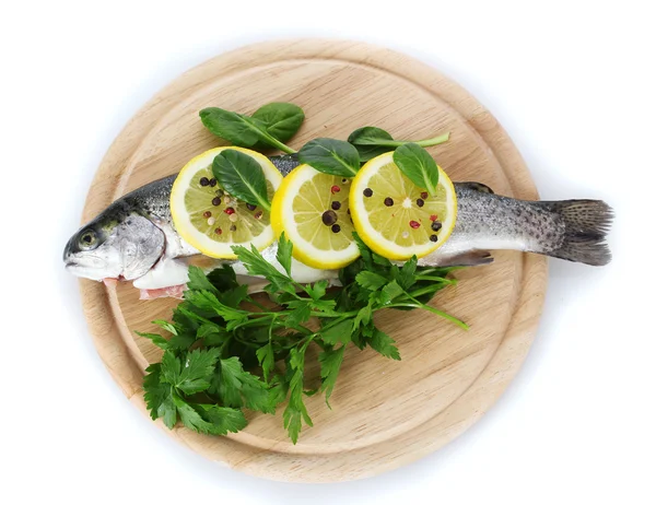 Pesce fresco con limone, prezzemolo e pepe su tagliere di legno isolato su bianco — Foto Stock