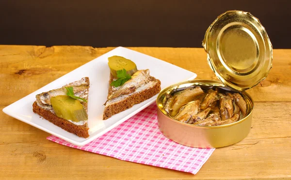 Läckra smörgåsar med skarpsill på plattan på träbord på brun bakgrund — Stockfoto