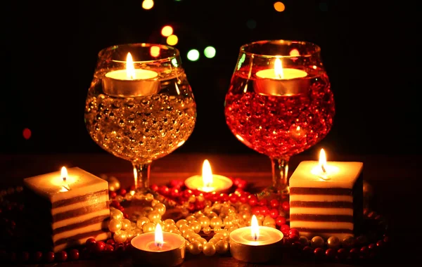 Amazing composition of candles and glasses on wooden table on bright background — Stock Photo, Image