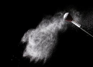 Make up brush with powder isolated on black clipart