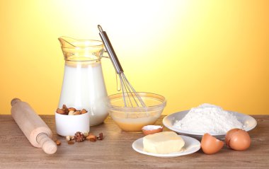 Ingredients for the dough wooden table on yellow background clipart