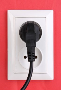 White electric socket with plug on the wall clipart