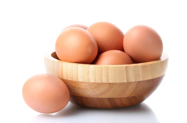 Ovos castanhos em tigela de madeira isolada em branco — Fotografia de Stock