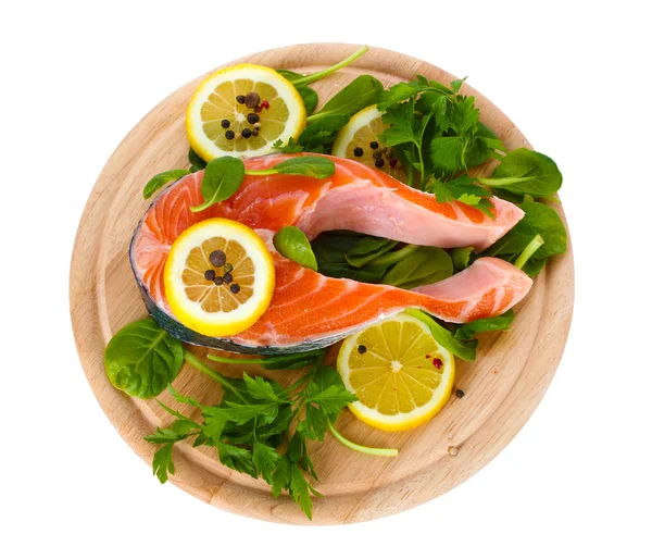 Pesce rosso con limone e prezzemolo su tagliere di legno isolato su bianco — Foto Stock