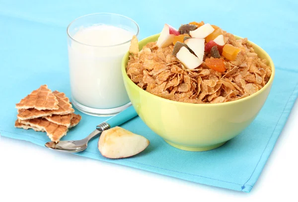 Sabrosos copos de maíz en un tazón con frutas secas y un vaso de leche en una servilleta azul —  Fotos de Stock