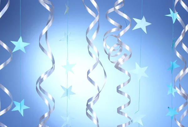 Schöne Luftschlangen und Sterne auf blauem Hintergrund — Stockfoto