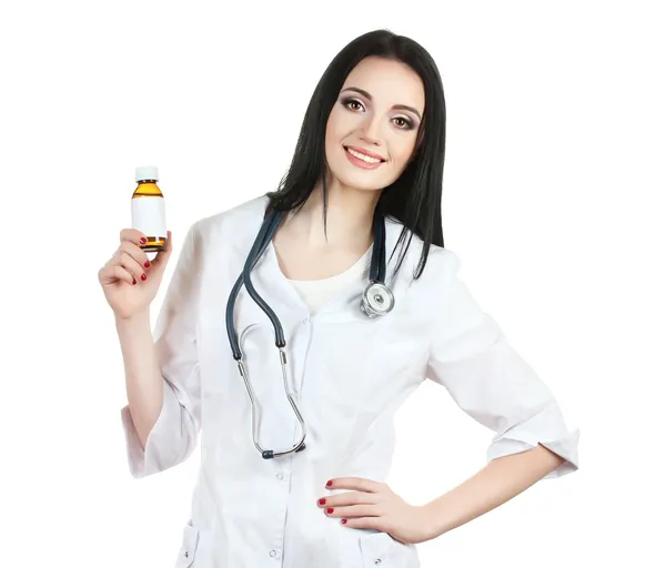 Mladá krásná doktor s stetoskop drží láhev s prášky izolovaných na bílém — Stock fotografie