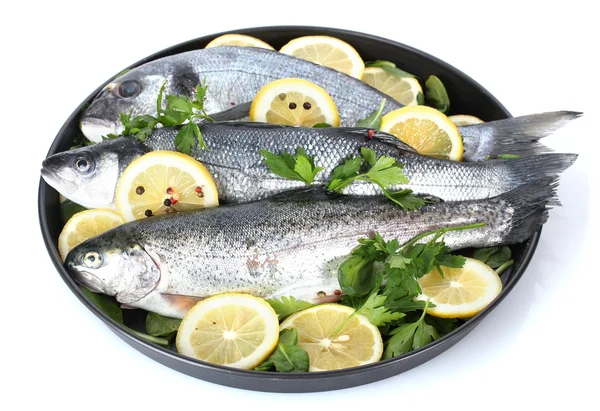 Свежие рыбы с лимоном, петрушкой и перцем на тарелке изолированы на белом — стоковое фото