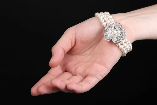 Perlenarmband an der Hand isoliert auf schwarz — Stockfoto