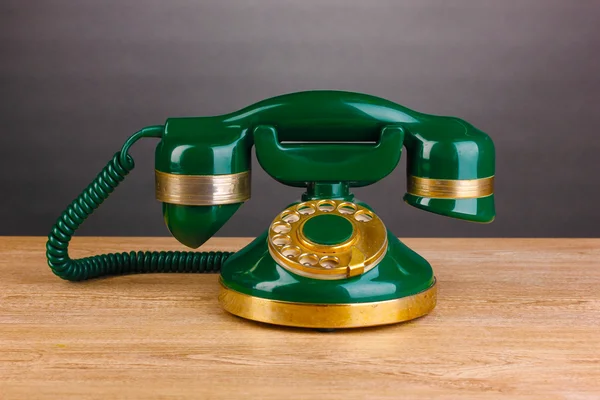 Retro phone on wooden table on grey background — Stock Photo, Image