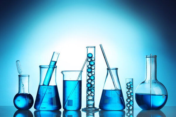 Test-tubes with blue liquid on blue background