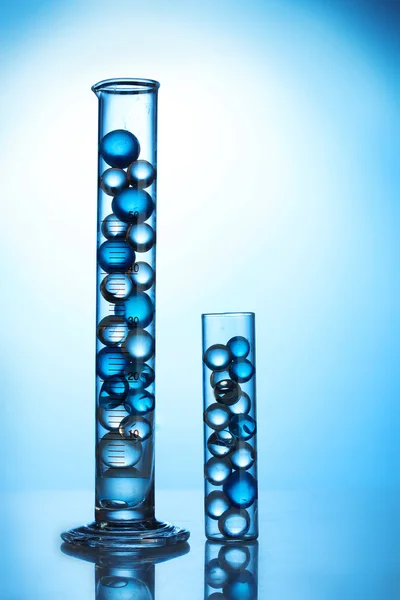 Tubes à essai avec hydrogel sur fond bleu — Photo