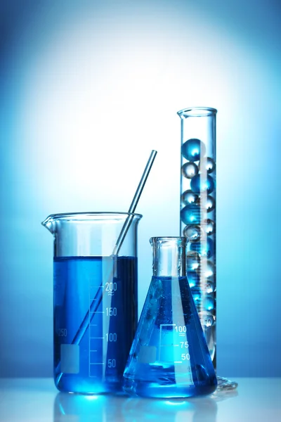 Тестовые трубки с голубой жидкостью на синем фоне — стоковое фото