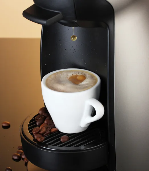 stock image Espresso machine pouring coffee in cup on brown background