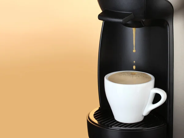 エスプレッソマシン茶色の背景にカップにコーヒーを注ぐ — ストック写真