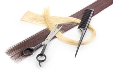 Shiny blond and brown hair with hair cutting shears and comb isolated on white