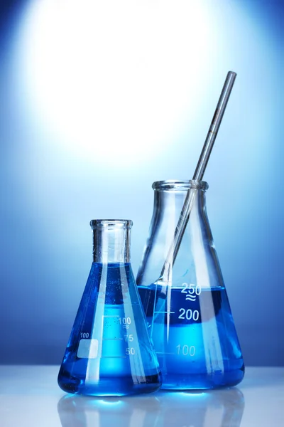Тестовые трубки с голубой жидкостью на синем фоне — стоковое фото