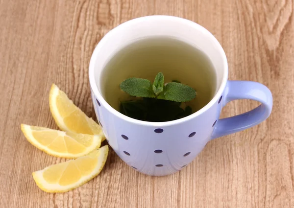 Мятный чай с мятой и лимоном на деревянном фоне — стоковое фото