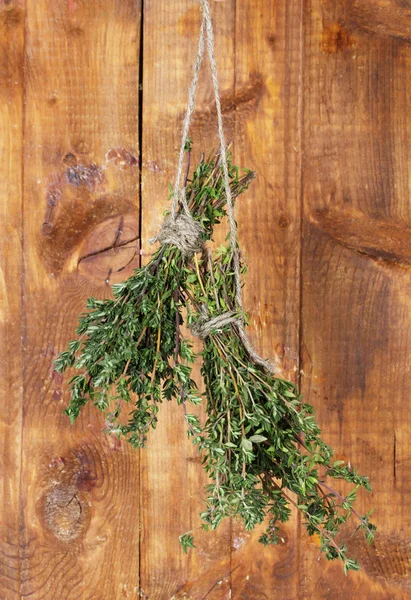 Fresh green thyme hanging on rope on wooden background — Stock Photo, Image