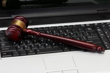 Wooden gavel on laptop computer close up clipart