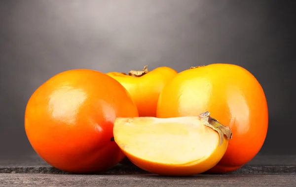 灰色背景上的木桌上的两个开胃柿子 — 图库照片
