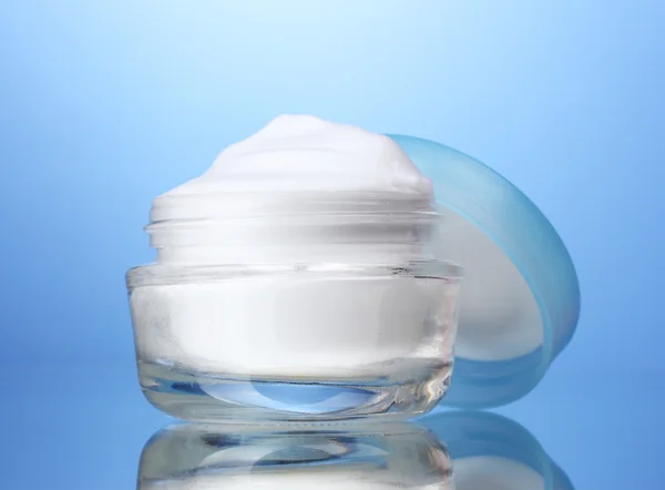 Crema cosmética sobre fondo azul — Foto de Stock